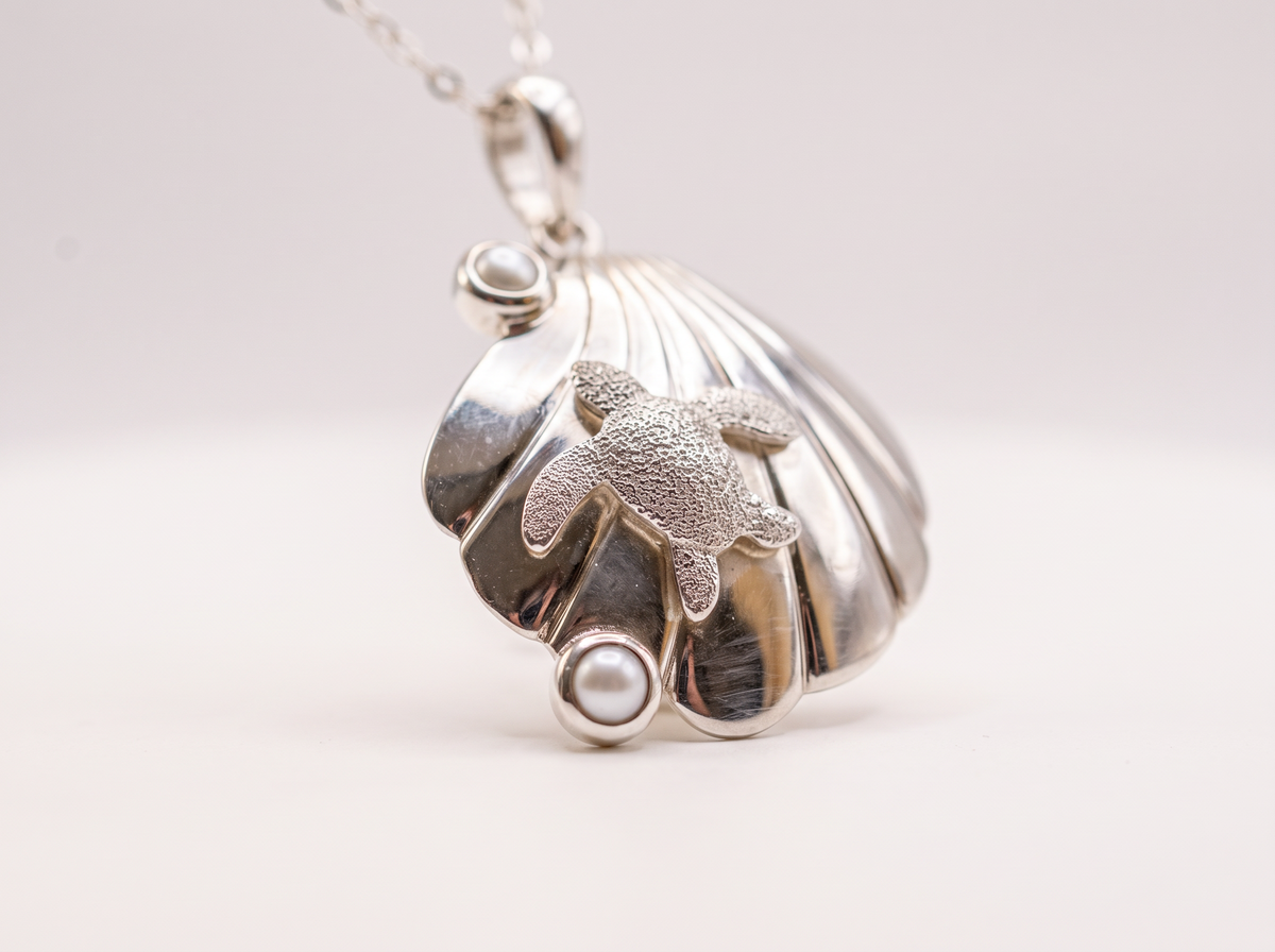 Sterling silver turtle resting on a seashell with two freshwater cultured pearls