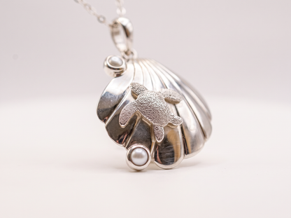 Sterling silver turtle resting on a seashell with two freshwater cultured pearls